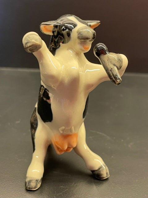 Porcelain Cow Singing with a Microphone.